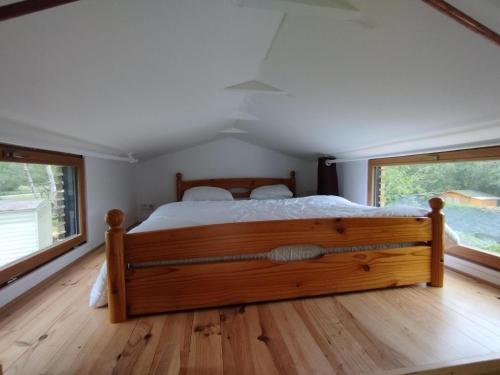 Tiny house في Naujac-sur-Mer: غرفة نوم بسرير كبير ونافذتين