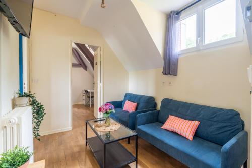 un salon avec un canapé bleu et une table dans l'établissement Appart 10personnes Jardin Parkings Voitures Vélos,10min Centre Blois,40min Zoo Beauval, à Blois