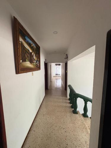 a hallway with a painting on the wall and a bench at Hotel Posada Del Carmen in Tekax de Álvaro Obregón