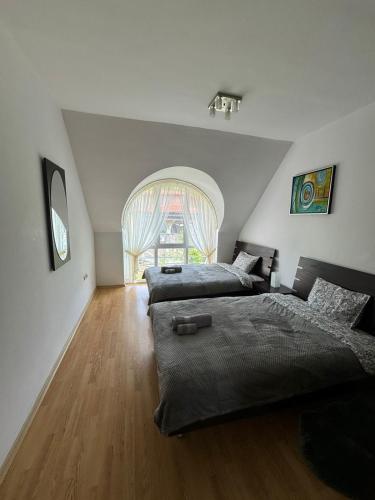 a bedroom with two beds and a large window at Apartment Skу in Kavarna
