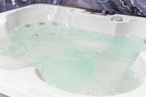a bath tub filled with green water in a bathroom at Cinema Studio Room with Spa Facilities For Couples in Cardiff