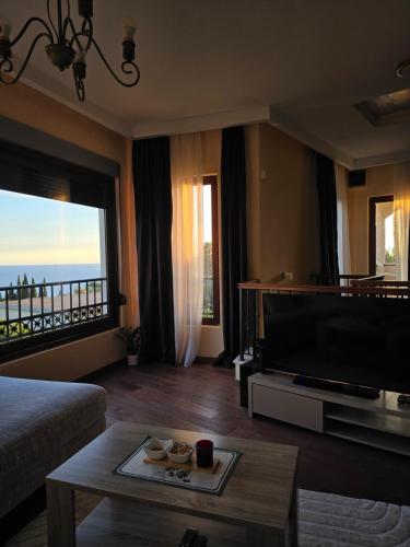 a living room with a television and a large window at Vista Blue Villa in Budva