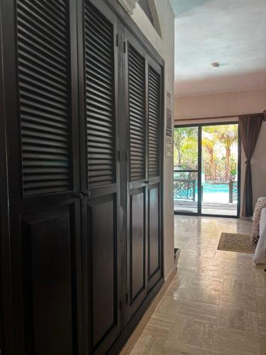 a room with black doors and a hallway with wood floors at Hotel Villas Tiburon Adults Only in Holbox Island