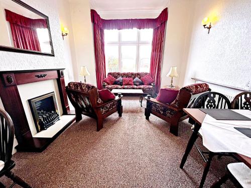 a living room with couches and a fire place at Affordable and Comfortable Guest House by Sea in Cleethorpes