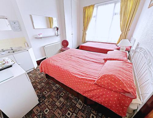 a small bedroom with two beds and a window at Affordable and Comfortable Guest House by Sea in Cleethorpes