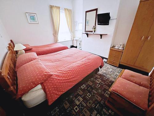 a hotel room with two beds and a mirror at Affordable and Comfortable Guest House by Sea in Cleethorpes