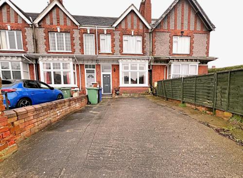 a blue car parked in front of a brick house at Affordable and Comfortable Guest House by Sea in Cleethorpes