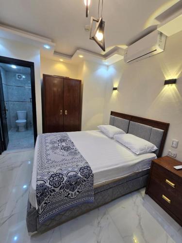 a bedroom with a bed and a bathroom with a toilet at chalet porto marina pool view in El Alamein