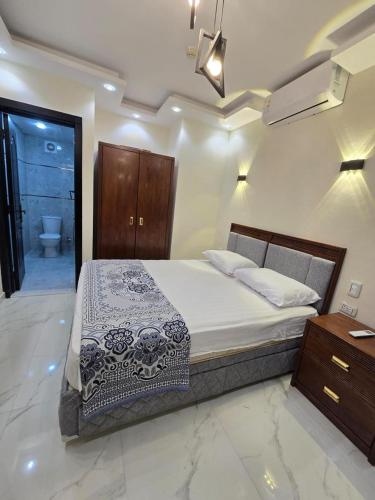a bedroom with a bed and a bathroom with a toilet at chalet porto marina pool view in El Alamein