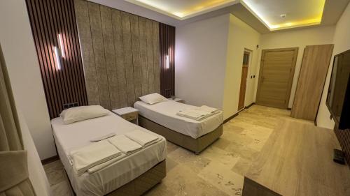 a hotel room with two beds and a television at Casablanca Garden Hotel in Nevsehir