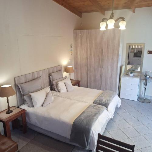 a bedroom with a large white bed with pillows at Lyn's Self Catering in Swakopmund