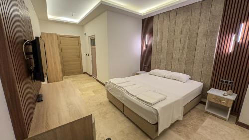 a bedroom with a white bed and a television at Casablanca Garden Hotel in Nevsehir