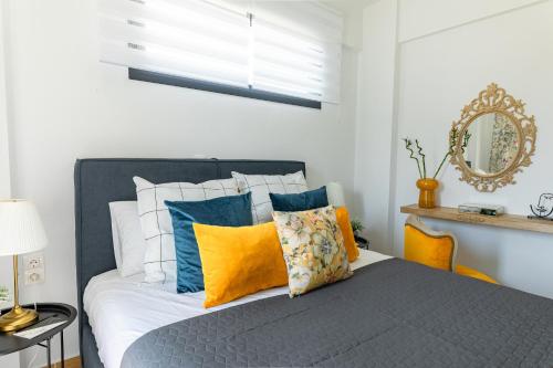 a bedroom with a bed with blue and yellow pillows at Mare Blue The Vintage Suite in Skala Rachoniou
