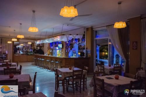 a restaurant with tables and chairs and a bar at Chandris Apartments in Kavos