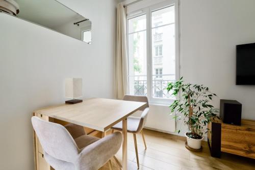 une salle à manger avec une table et des chaises et une fenêtre dans l'établissement Parisian Charm, Modern & Quiet Studio, à Paris