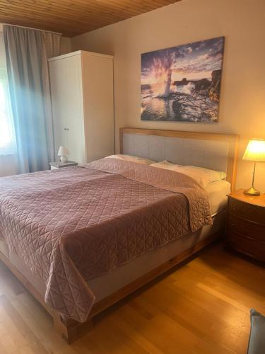 a bedroom with a bed and a painting on the wall at Ferienwohnungen zum Attersee in Lenzing