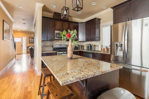 Una cocina con una mesa con un jarrón de flores encima. en Garfield 2BR - New Build - Foodie-Friendly Stay, en Portland