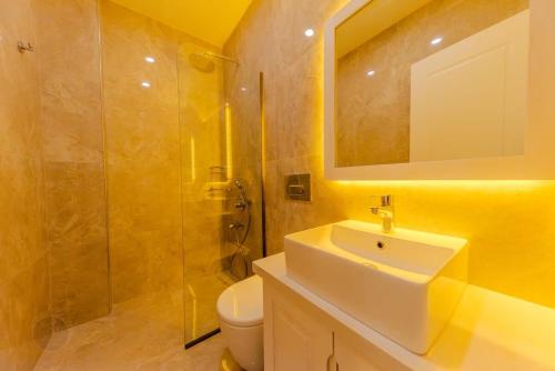 ein Badezimmer mit Waschbecken, Toilette und Spiegel in der Unterkunft Holidays are the best days, villa vacation is great in Çavdır