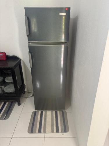 a stainless steel refrigerator in a corner of a kitchen at June’s comfort paradise in Runaway Bay