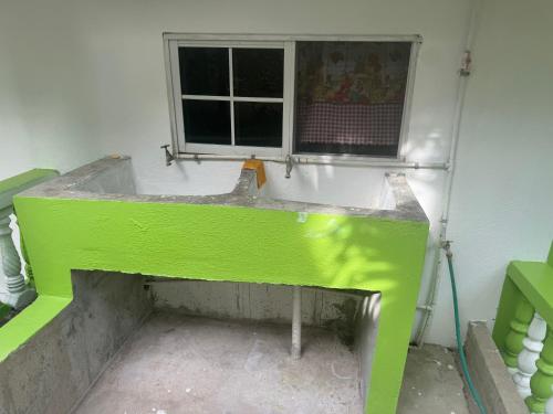 a green bench in a room with a window at June’s comfort paradise in Runaway Bay
