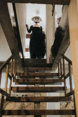 a woman in a black dress walking down a staircase at Bajo Estrellas Hotel Contemporáneo in Valle de Guadalupe