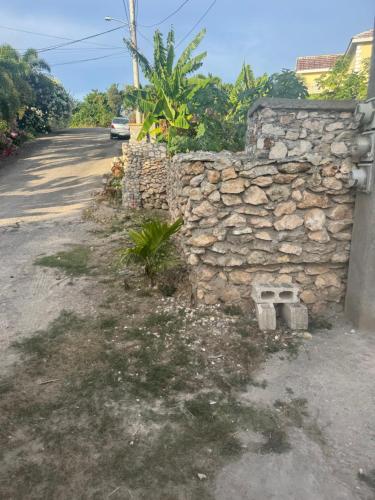 a stone wall on the side of a road at June’s comfort paradise in Runaway Bay
