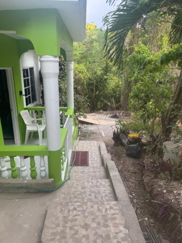a green and white house with a walkway at June’s comfort paradise in Runaway Bay