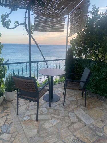 a patio with a table and chairs and the ocean at Villa Scorpio in Qeparo
