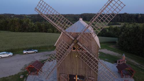 a large wooden windmill in the middle of a field at Wiatrak in Ręboszewo