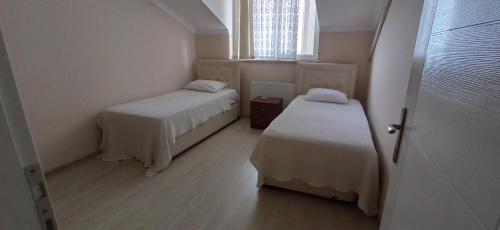 a small room with two beds and a window at Alasraf Suite in Akcaabat