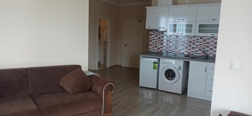 a living room with a couch and a washing machine at Alasraf Suite in Akcaabat
