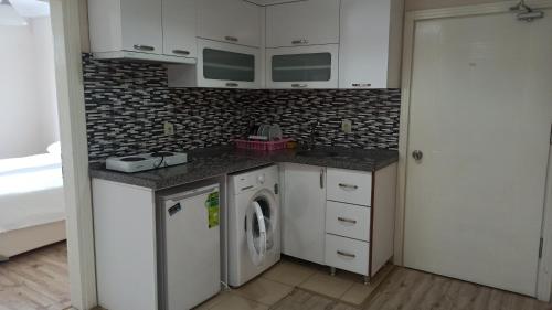 a kitchen with a washer and dryer in a room at Alasraf Suite in Akcaabat