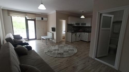 a living room with a couch and a kitchen at Alasraf Suite in Akcaabat