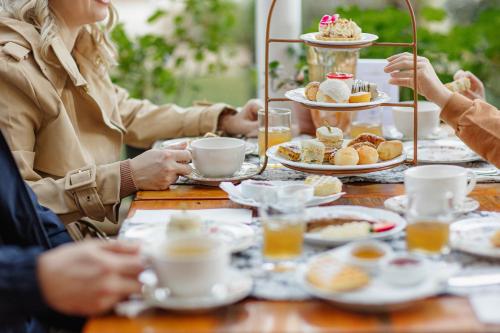 a group of people sitting around a table with food at Hotel Ritta Höppner in Gramado