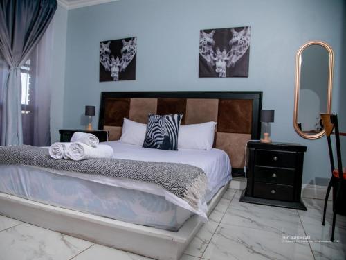 a bedroom with a large bed and a mirror at Heri guest house in Johannesburg
