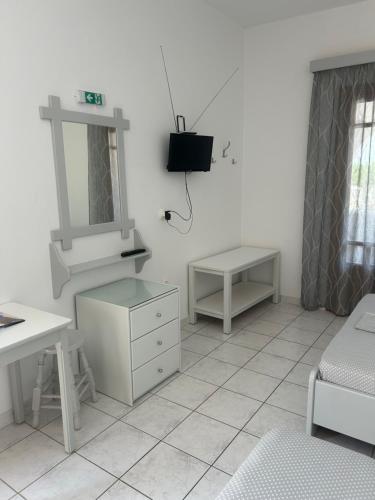 a white bathroom with a sink and a mirror at Theoni Studios in Kastraki Naxou