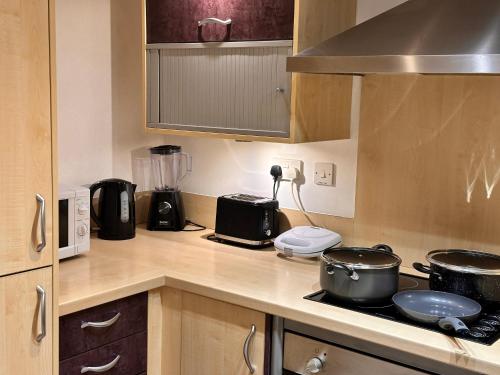 a kitchen with two pots and pans on a stove at Enjoy city living in this one-bedroom flat, complete with a balcony and secure parking in Birmingham city center in Birmingham