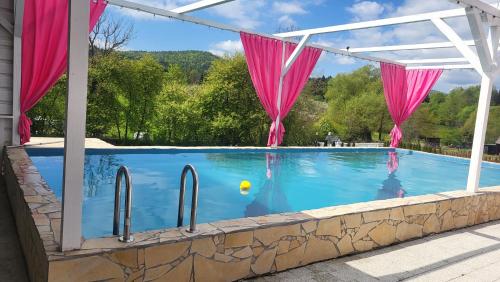 a swimming pool with pink drapes over it at Lawendowy dworek in Paszowa