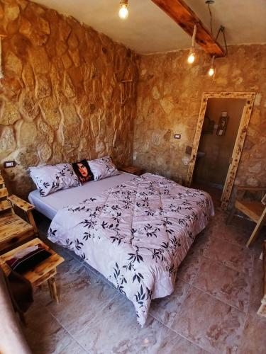 a bedroom with a bed in a stone wall at Friends of Dana Hotel in Dana