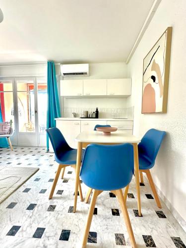 une salle à manger avec une table et des chaises bleues dans l'établissement Superbe 4 couchages avec terrasse - Clim - 50m de la mer, à Saint-Raphaël