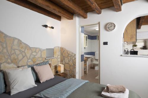 a bedroom with a bed and a clock on the wall at Apartments Casa Antico in Premantura