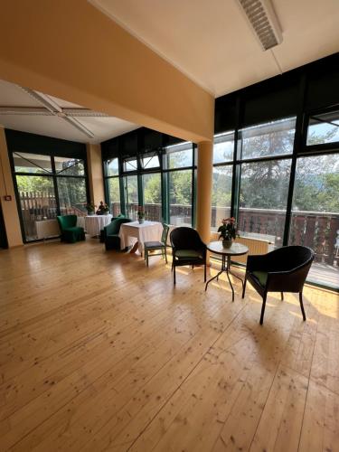 a large room with tables and chairs and windows at Das Alpl Resort in Krieglach