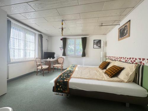 ein Schlafzimmer mit einem Bett und einem Tisch und Stühlen in der Unterkunft Seehotel Schwert in Gersau