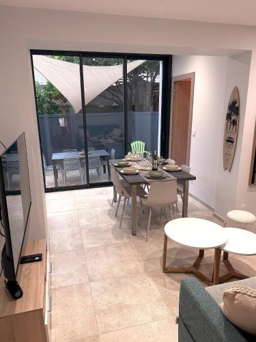 un salon avec une table et des chaises de salle à manger dans l'établissement Hébergement de Standing à la Mer avec extérieur, à Banyuls-sur-Mer