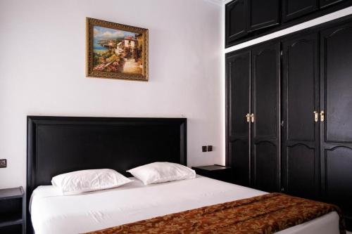 a bedroom with a bed and a picture on the wall at Hotel Apart LRB in Marrakech