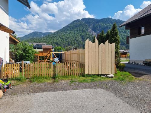 a wooden fence in a yard with mountains in the background at Ferienhaus Michael in Scharnitz
