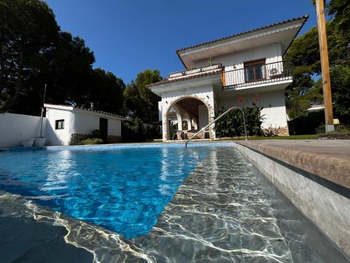 a villa with a swimming pool in front of a house at Villa Allyson Boutique Guesthouse in Lloret de Mar