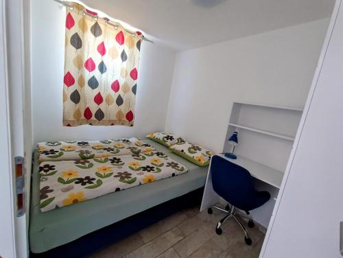 a small bedroom with a bed and a desk at Heart of Strunjan Apartments AL in Strunjan