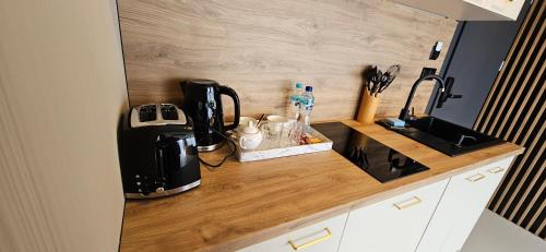 a kitchen counter with a coffeemaker and a coffee maker at Siedmiu Króli Rooms&SPA in Bukowina Tatrzańska