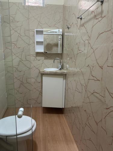 a bathroom with a sink and a toilet and a mirror at Casinha da Ana in Bacabal